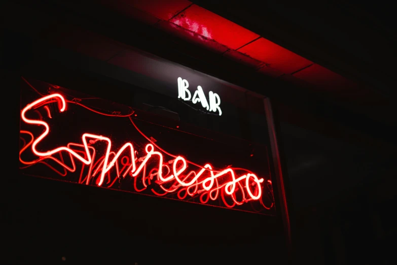 this neon sign is on the wall next to a bar