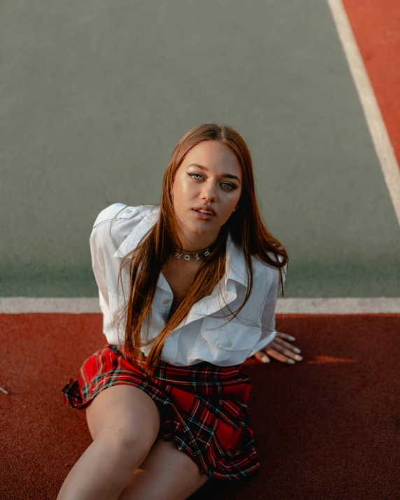 a pretty young lady sitting on top of a tennis court