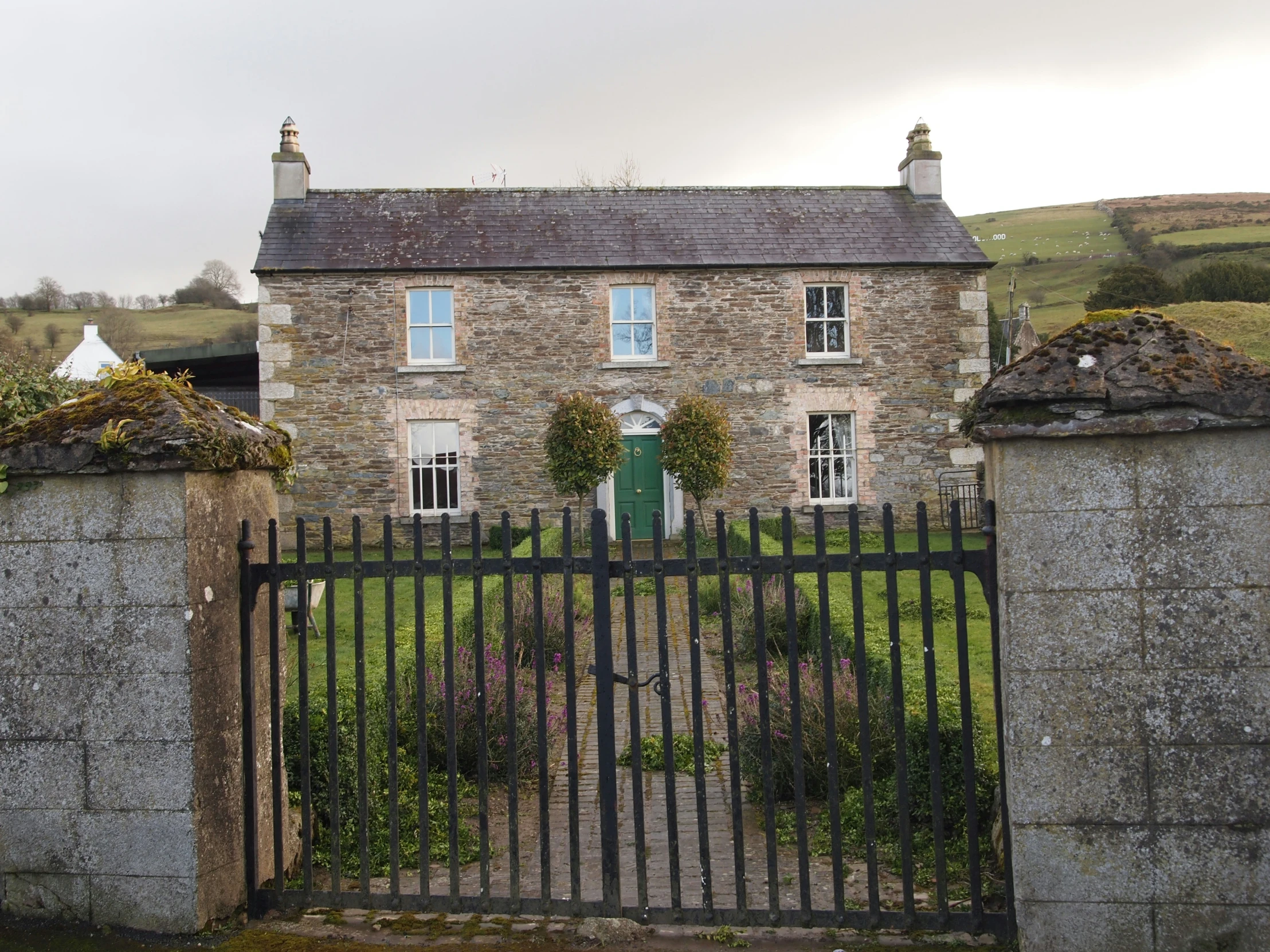 a house is shown with a stone gate