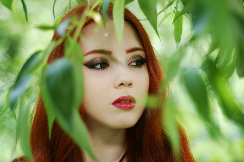 a girl with red hair and brown eyes wearing makeup