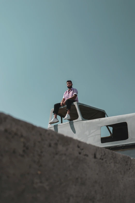 a man sitting on a ledge with his arms crossed