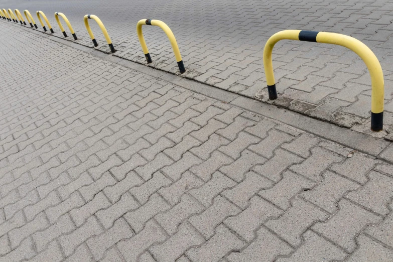 two yellow and black metal barriers are set up along the side of a paved street