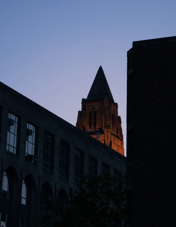 a tall building is silhouetted by the setting sun