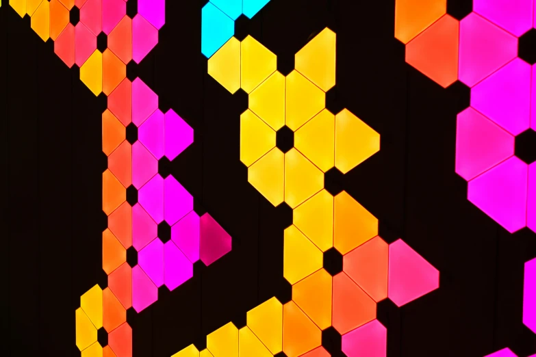 colorful neon tiles in a pattern on a black wall