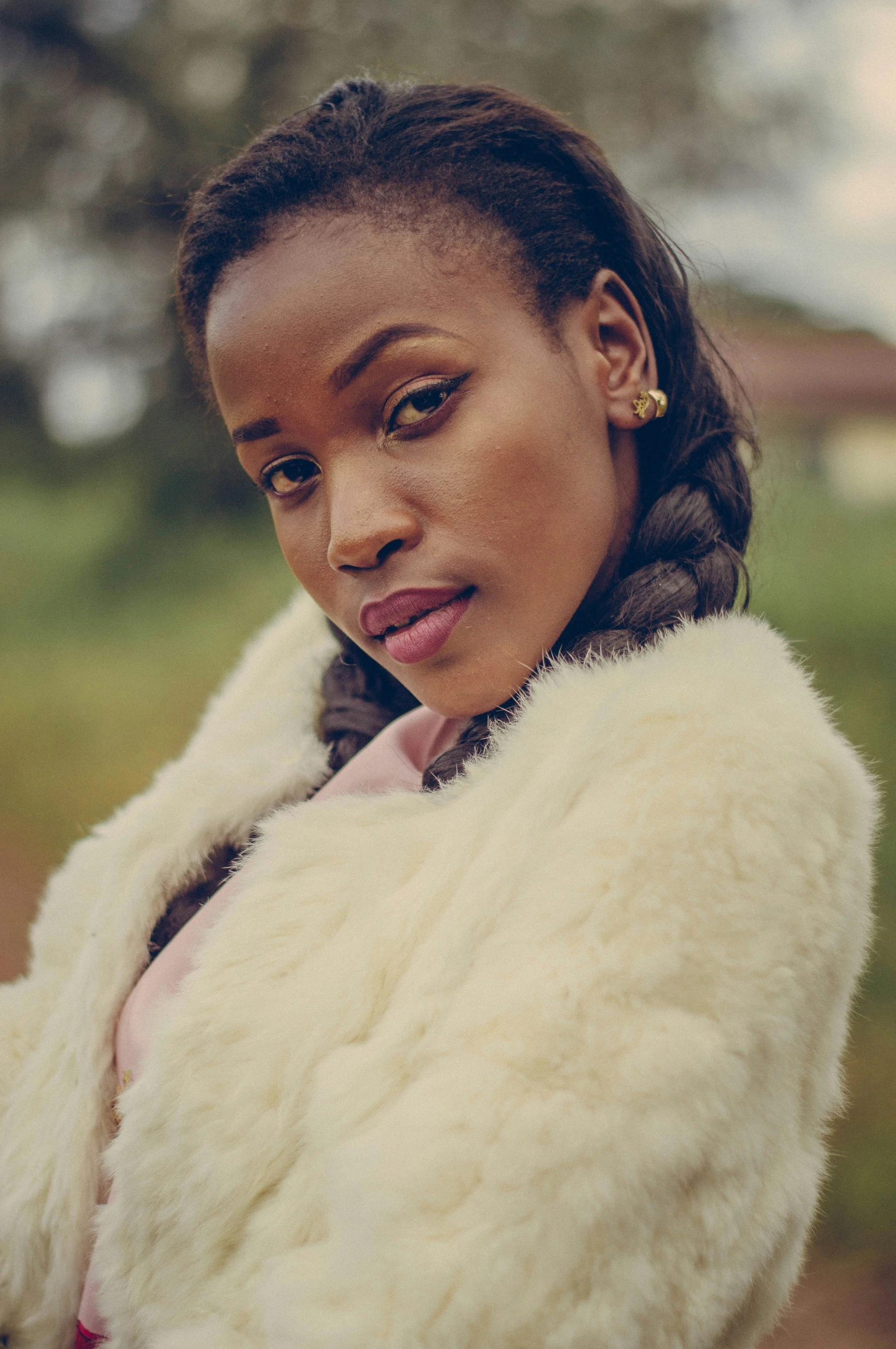 a woman in a white jacket is standing outside