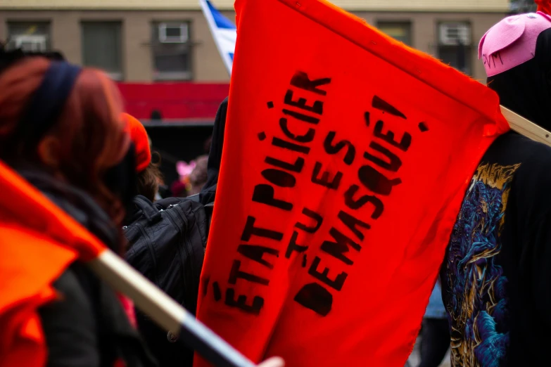 people holding up red signs and banners in a street