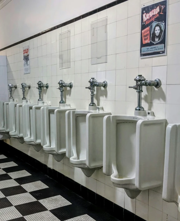 there are white urinals and black and white tile