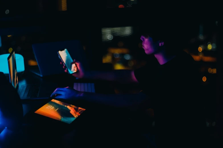 a couple of people sitting in front of laptop computers