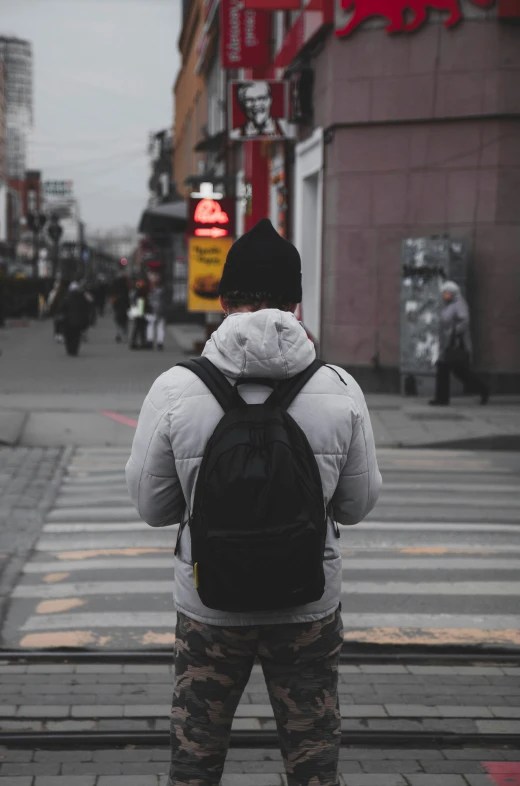 the man is waiting to cross the street in the city