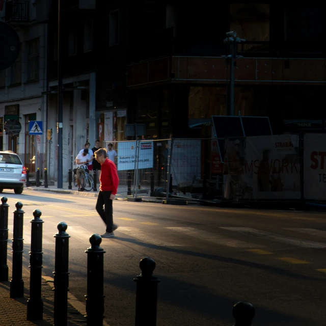 a man is walking down the street in the evening