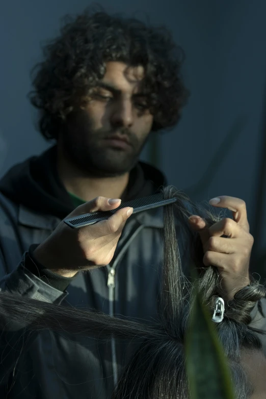 a man with curly hair doing some scissors