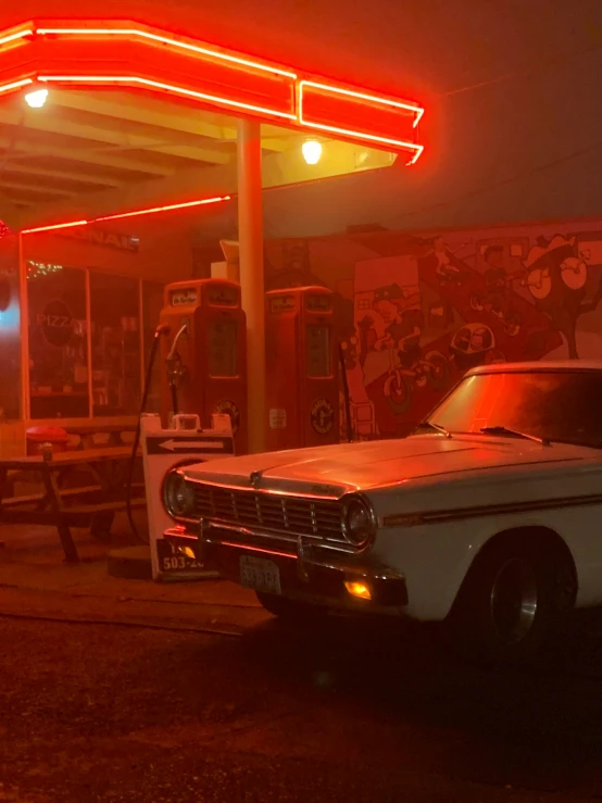 a couple of cars in front of a gas station