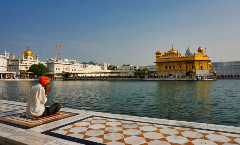 a person is sitting on a dock in front of a body of water