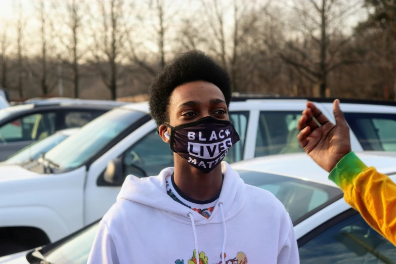 a black lives matter face covering in front of parked cars