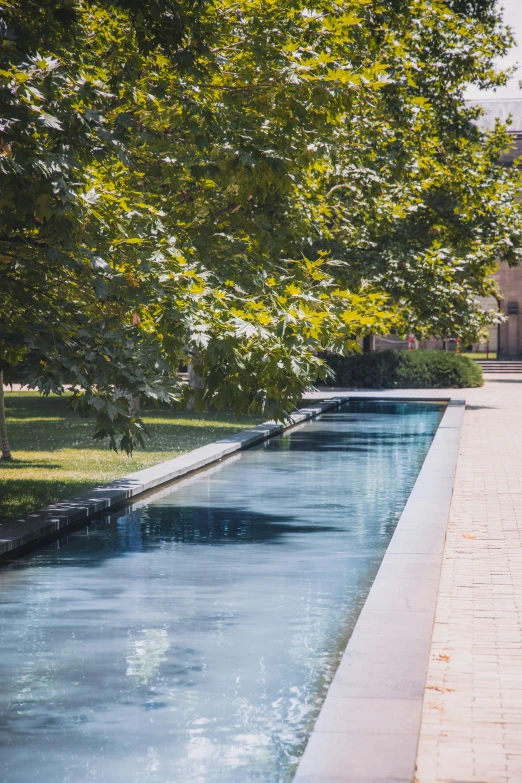 a long pool with blue water running between two sides of it