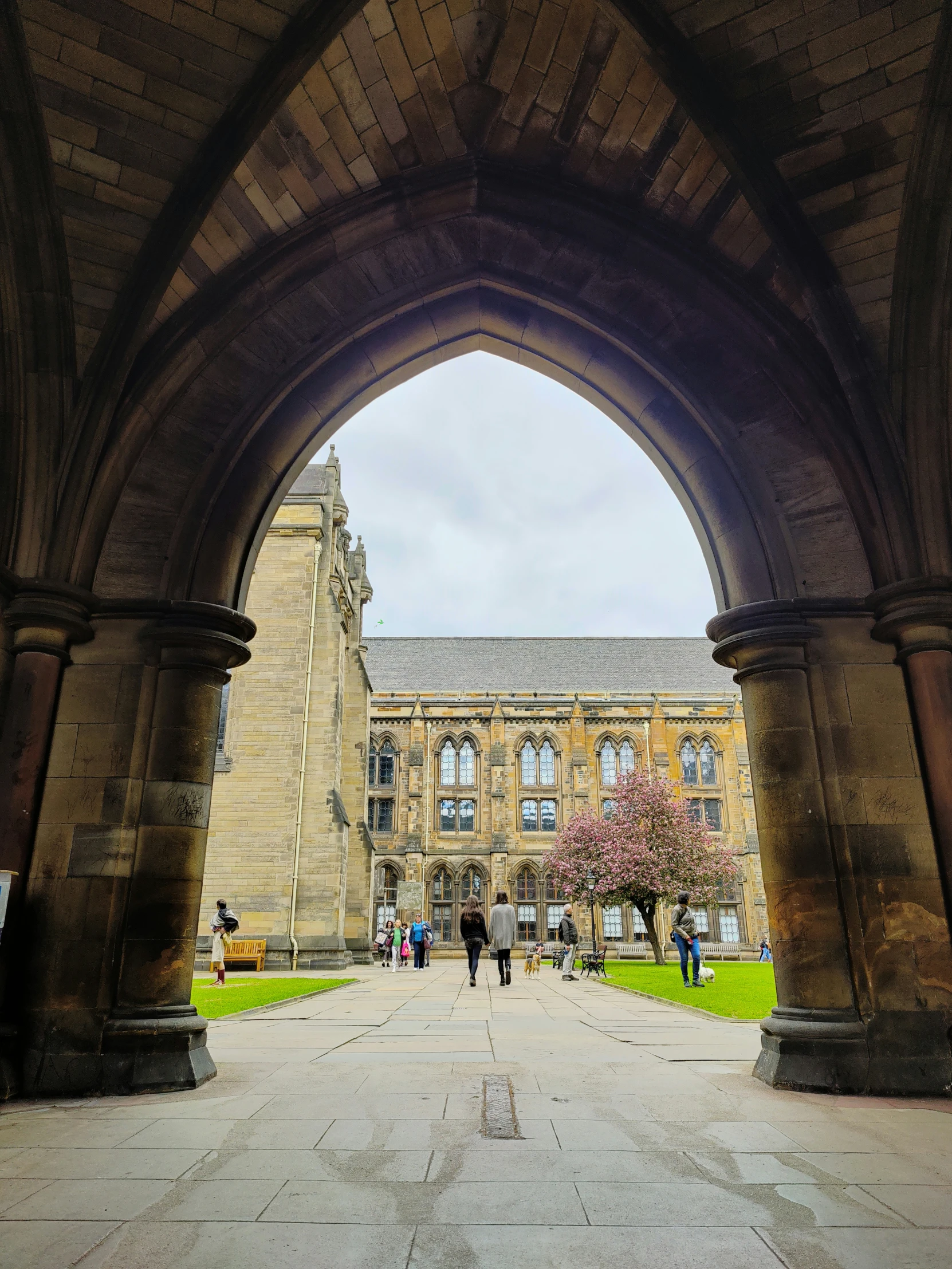 a clock tower and other large buildings through a stone arch