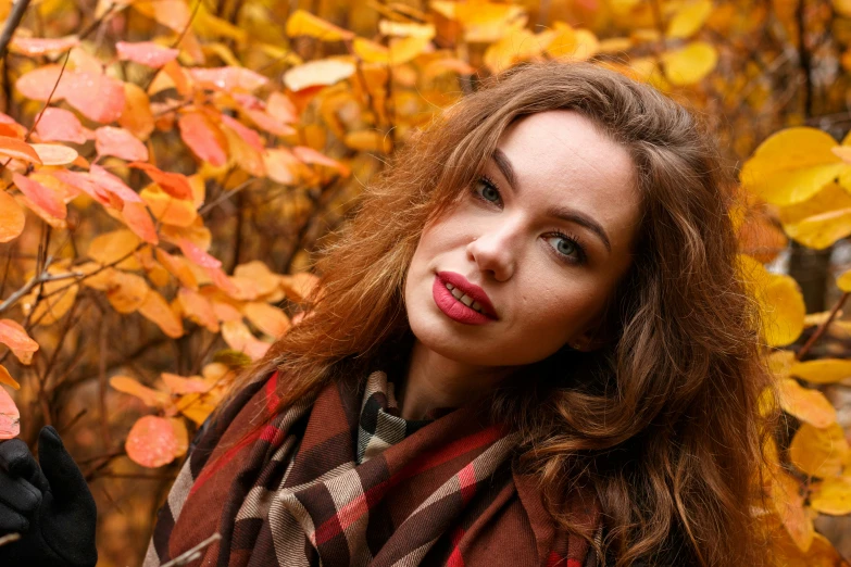 a woman in the park posing for a picture with leaves