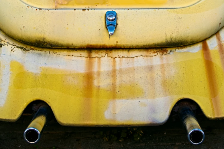 this is an old yellow bus parked with its exhaust tubes up