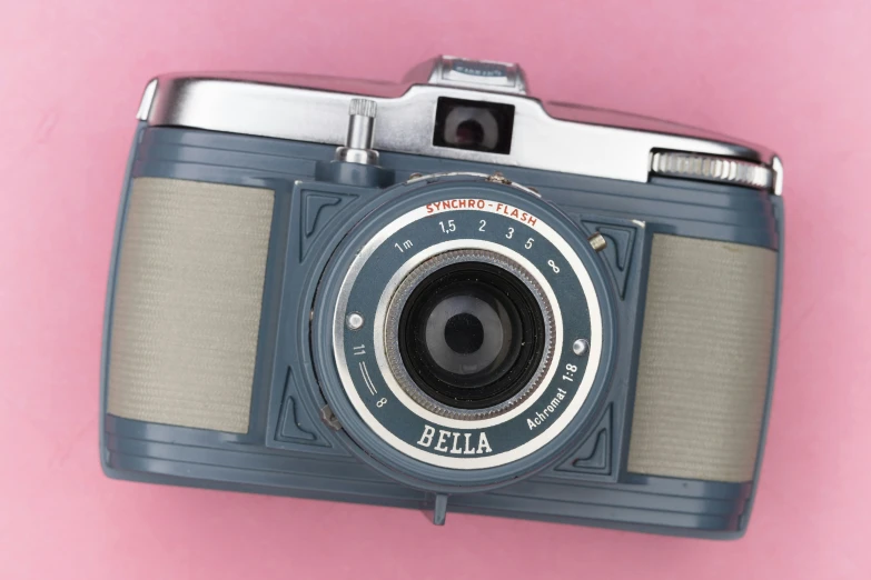 a old fashioned camera on a pink background