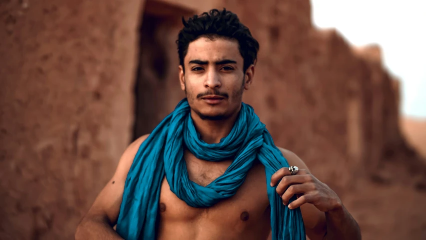 a shirtless young man in the middle of some adobe - town