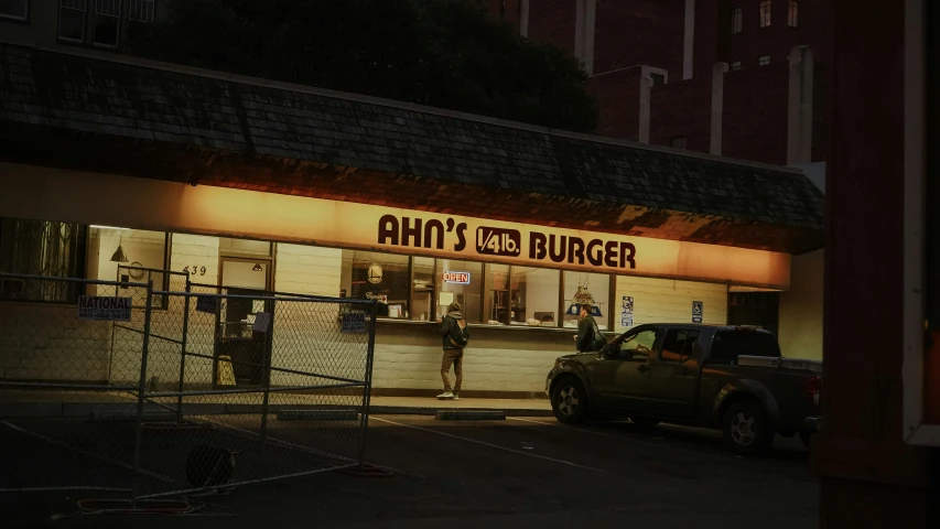 a car parked in front of an empty burger restaurant