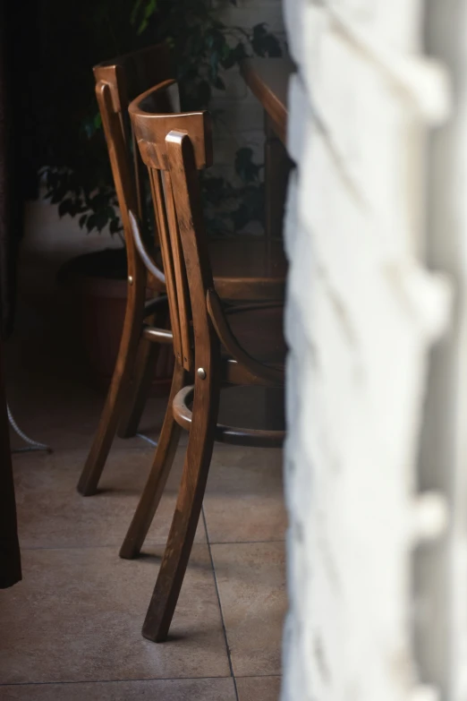 a couple of wooden chairs sitting inside of a house