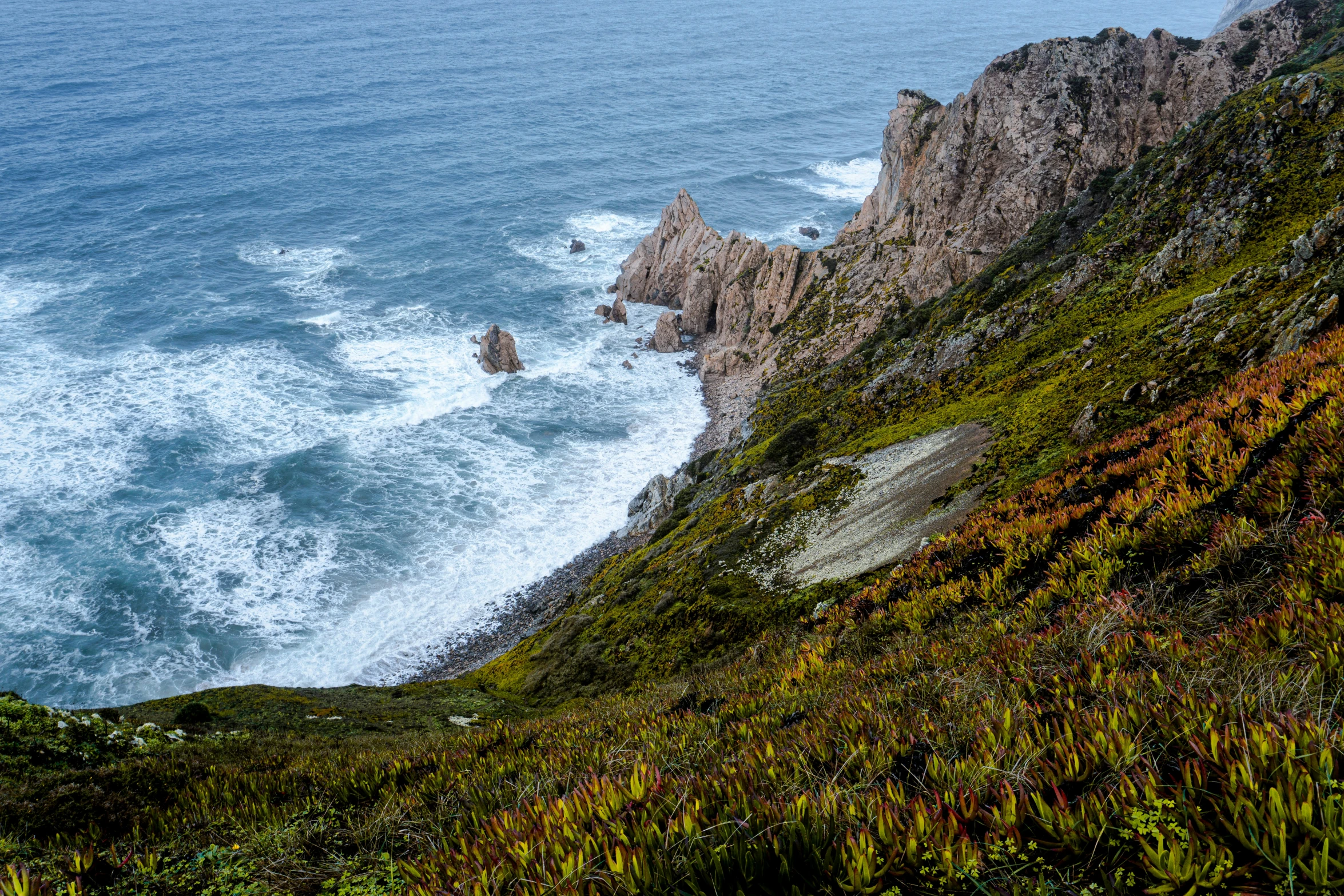 view from the top of a mountain looking down on a beach