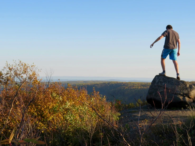 a man standing on top of a rock with his hands up