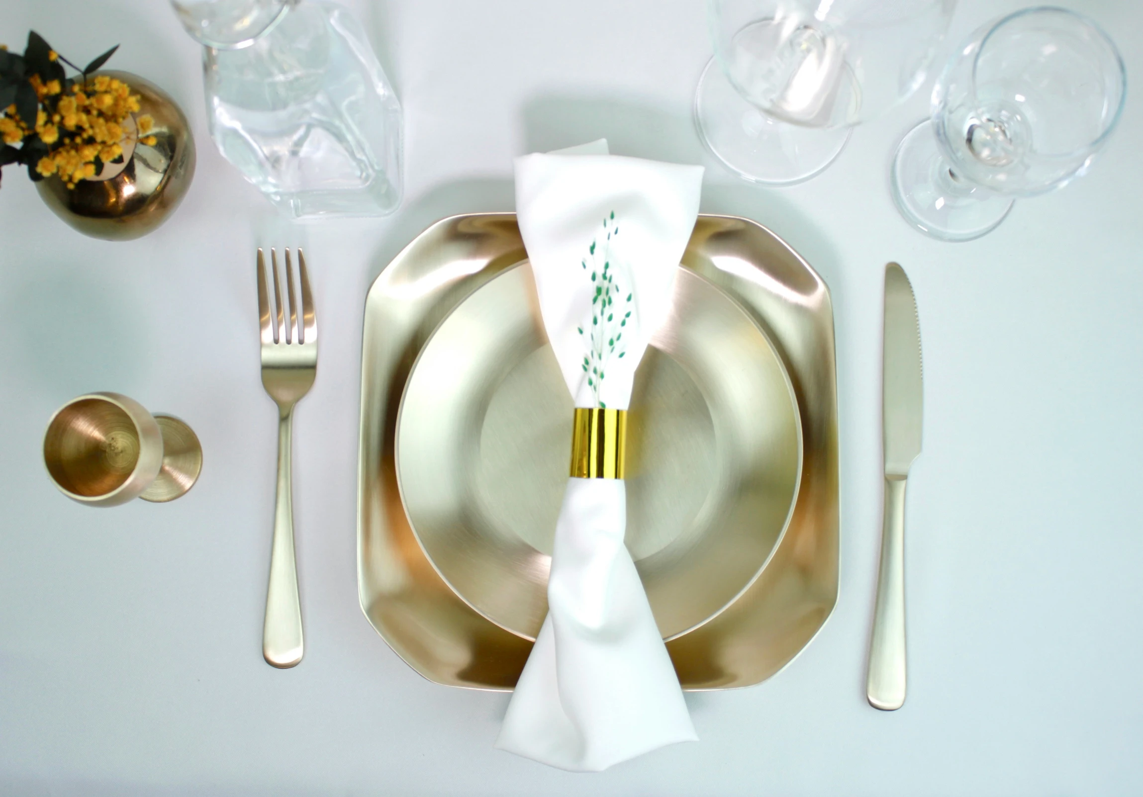 a place setting for a wedding dinner with wine glasses and silverware