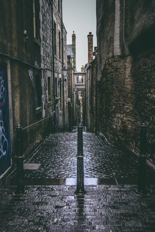 a street with buildings is wet and a clock tower