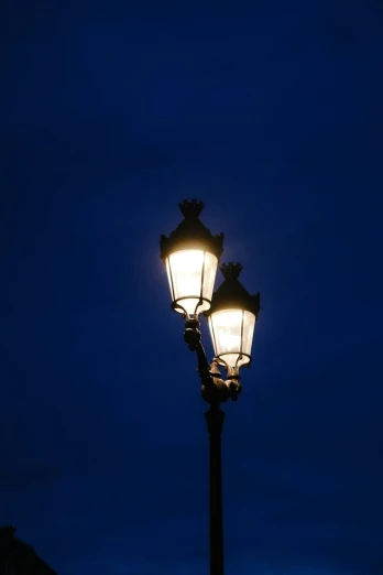 a street light is lit at night in front of the city skyline