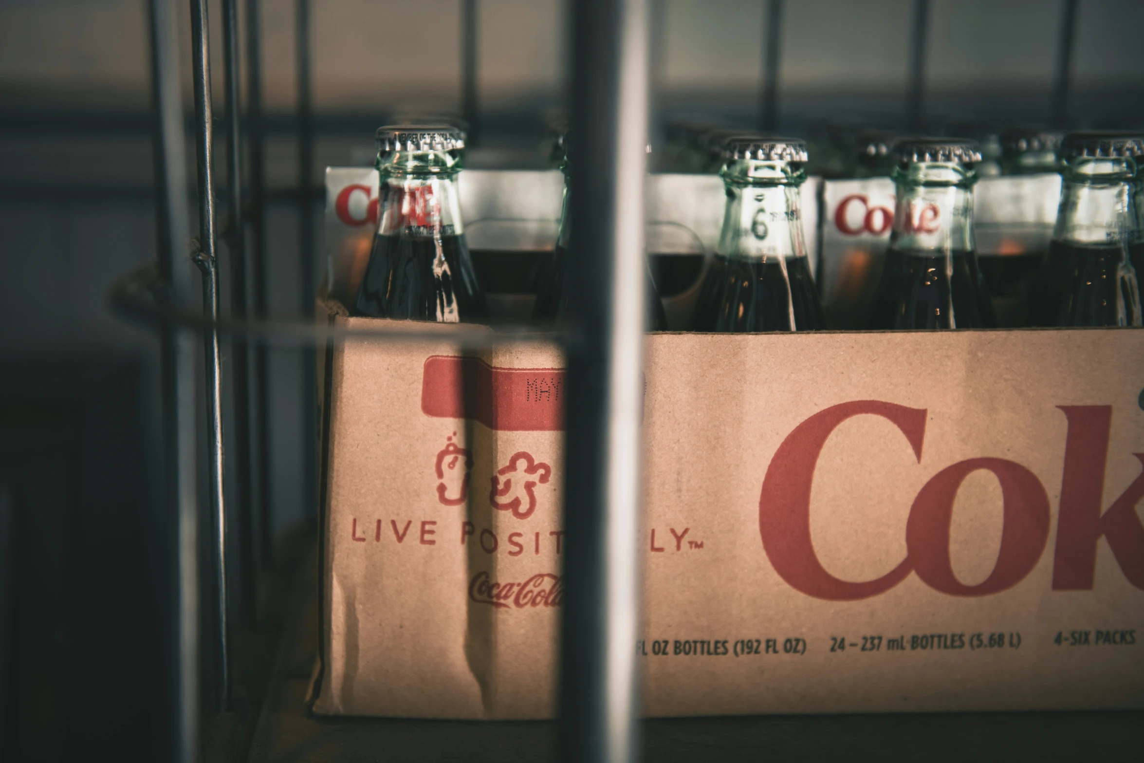 an opened box with six coke bottles