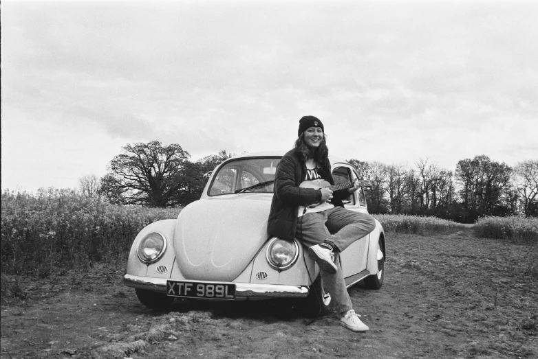 a couple of people sitting on the back of a volkswagen beetle