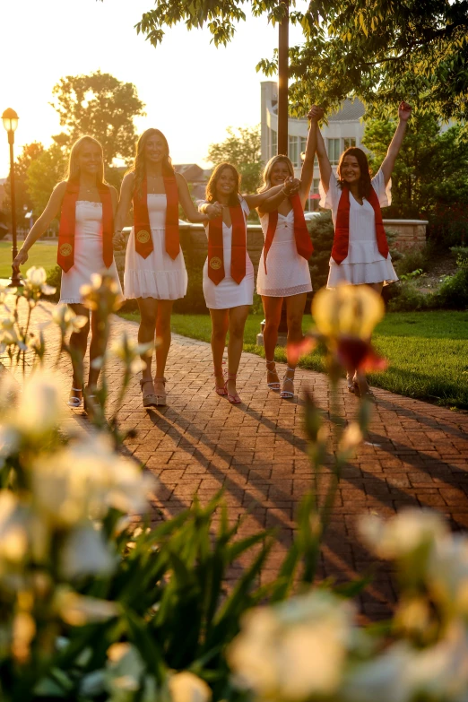 a group of young women walking across a sidewalk