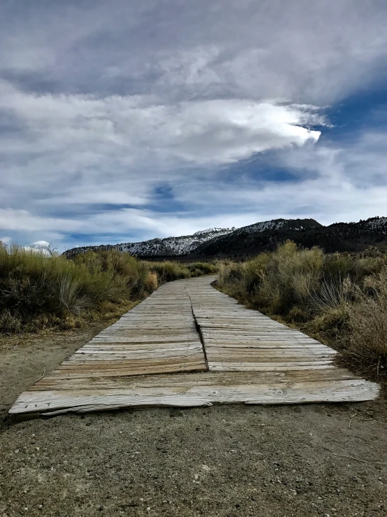 a bench made out of a log on top of gravel