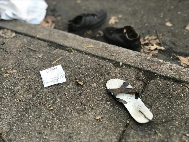 a pair of shoes are sitting on the curb by a mailbox