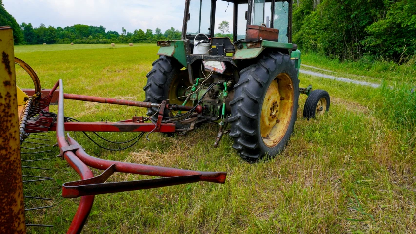 a tractor in the middle of the field with grass