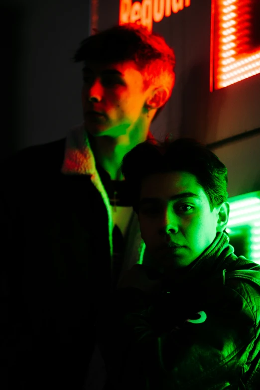 two men in the background of a neon neon sign