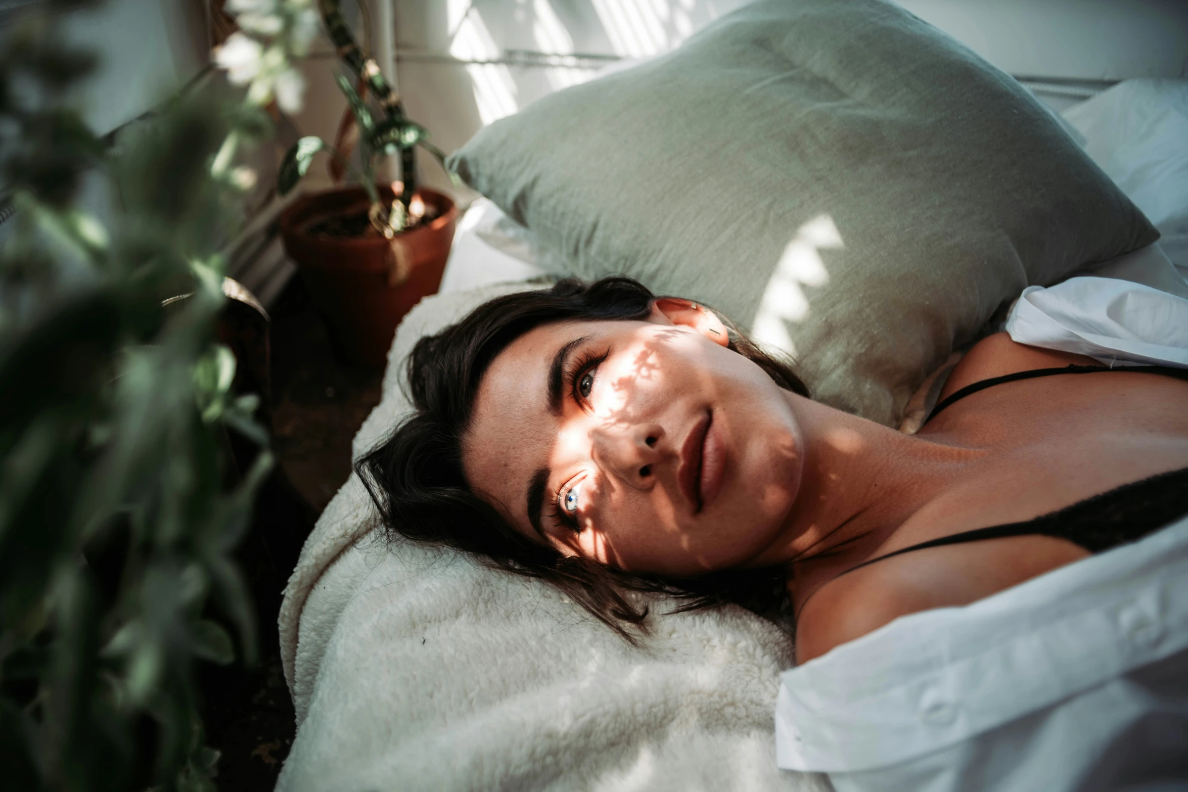 woman laying down with a white blanket on her back