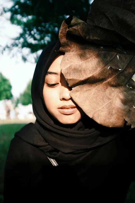 a woman with a black headdress is wearing a scarf over her head