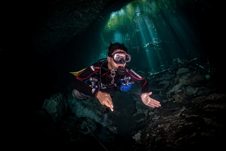 a man swimming towards the camera while wearing scuba gear