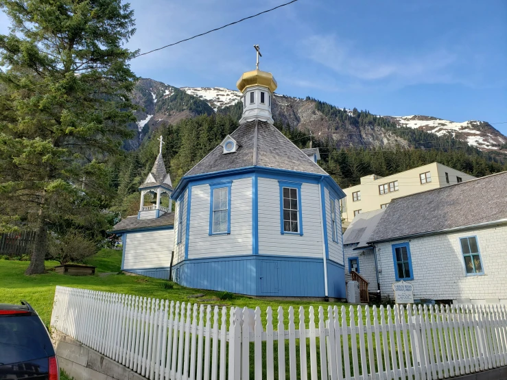 a little church near the country side with a mountain in the background