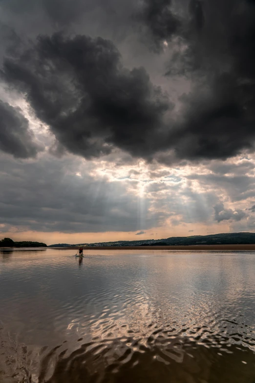 the sun's rays shine through clouds over water