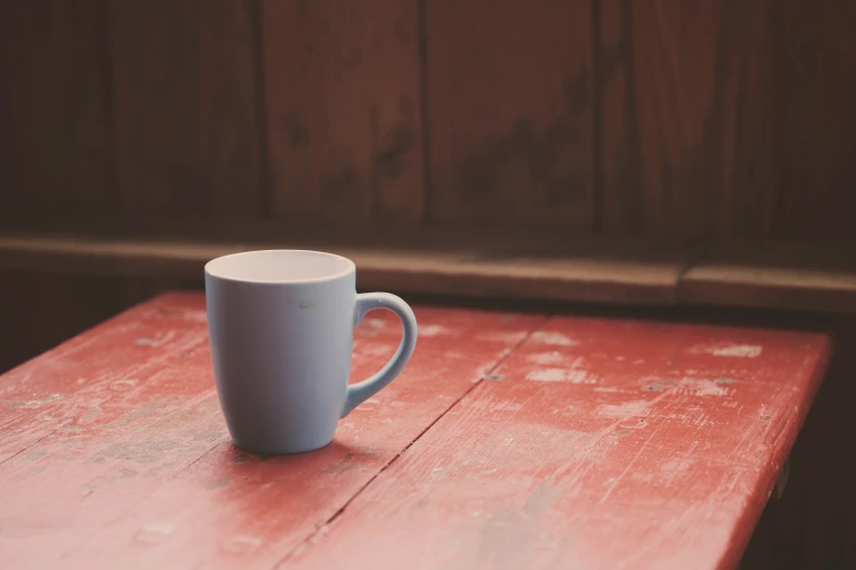 a cup sitting on top of a red table