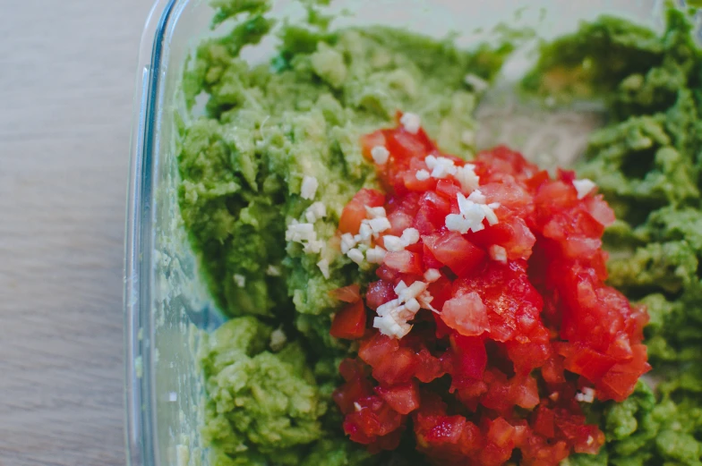 a dish with broccoli, tomatoes and other food in it