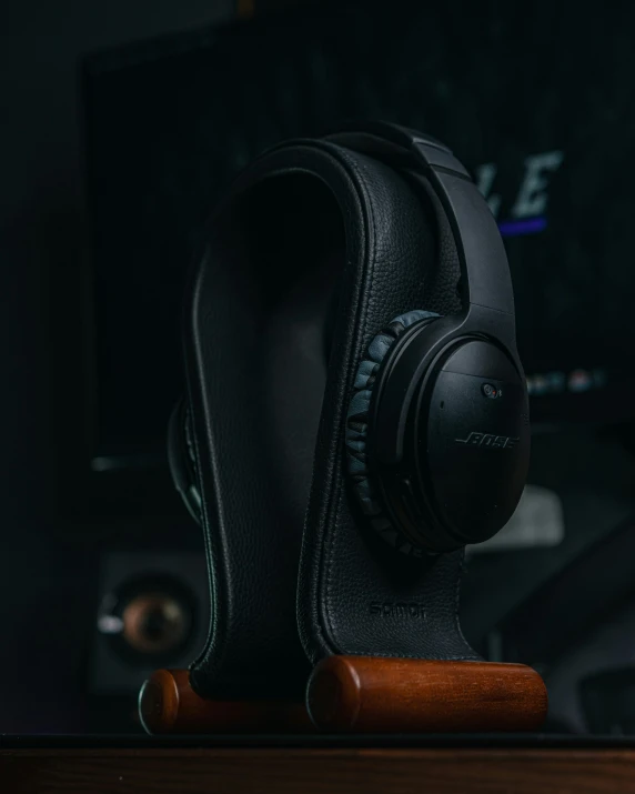 black headphones with wooden stand on desk