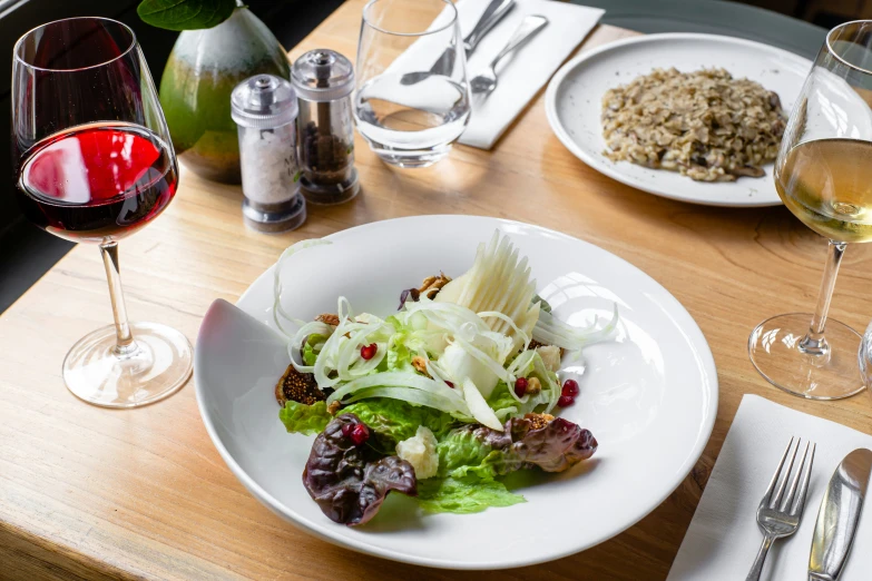 a plate with food and glass of wine on a table