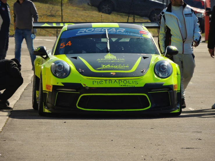 a man is standing beside a racing car