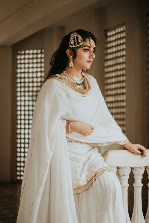 a woman in a white outfit sitting on top of a chair