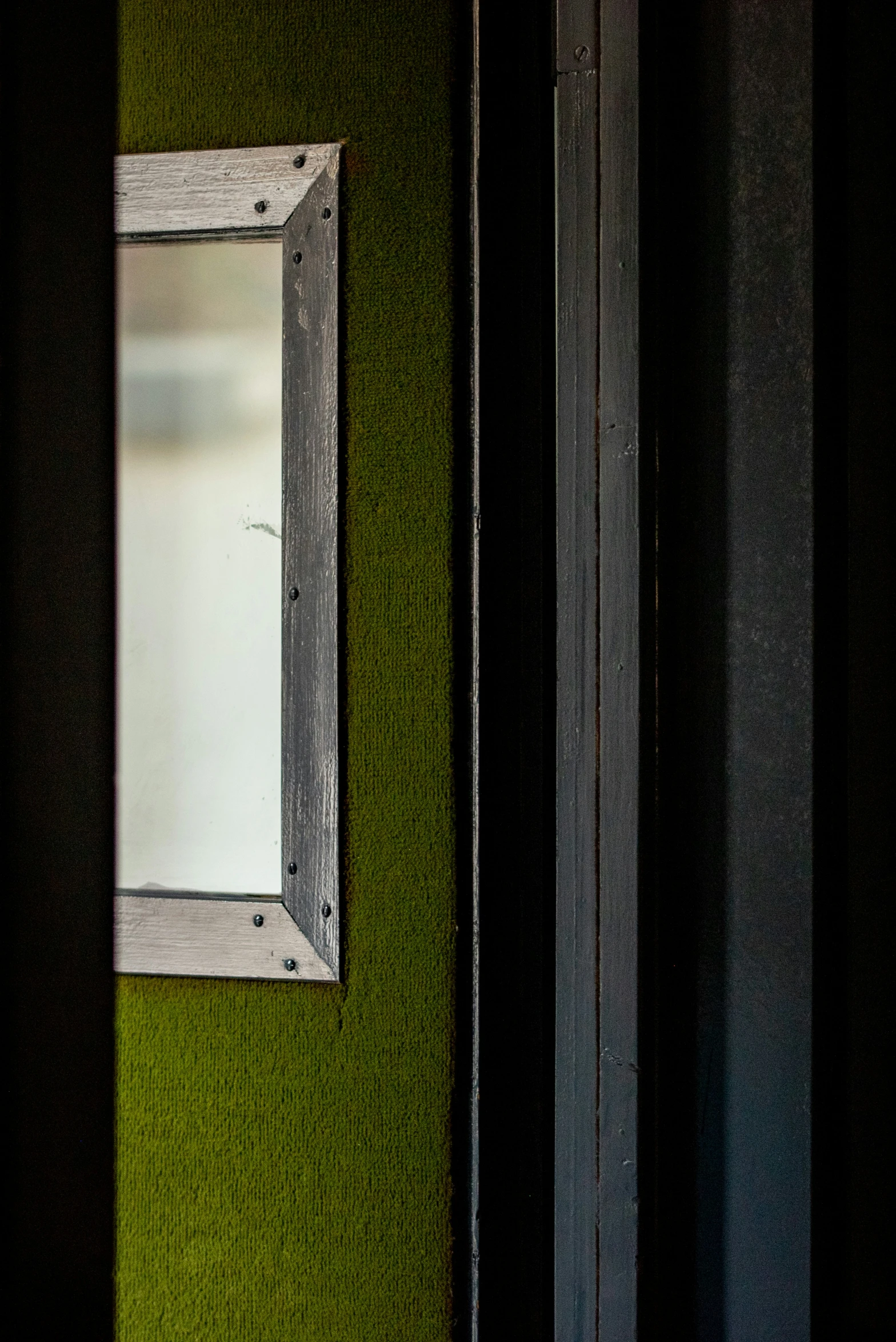 a door with green walls and a small mirror on it